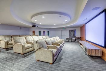 A movie theater with rows of seats and a large screen.